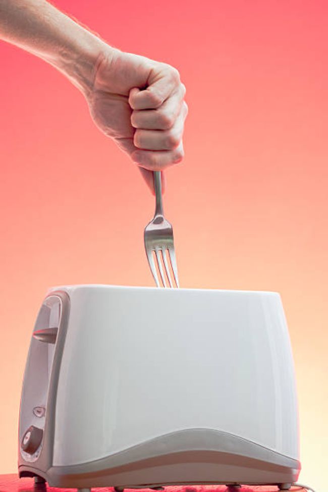 an image of fork sticking in the toaster