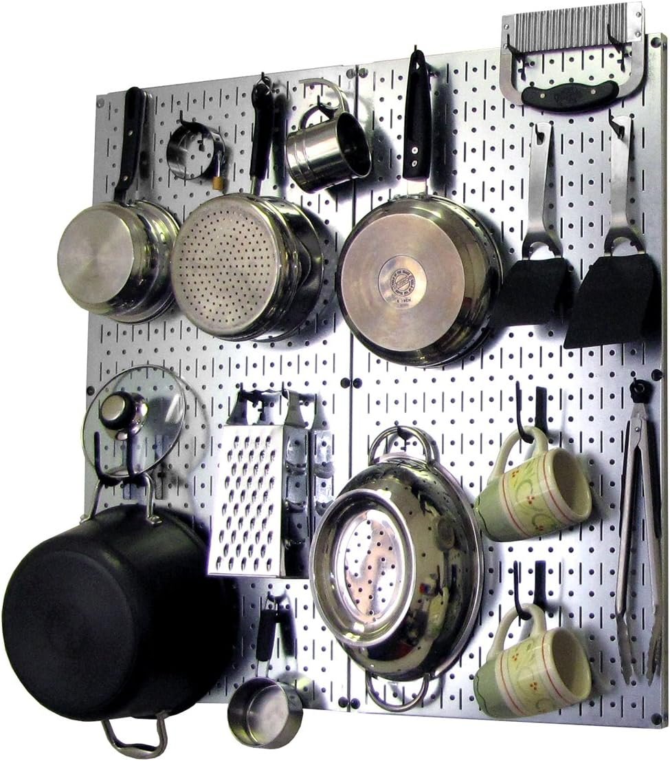 Metal kitchen pegboard organizer panel with shelves and hooks holding pans and utensils